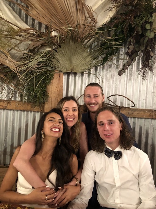 Brittany and Deklan smiling closely with loved ones at a celebration.
